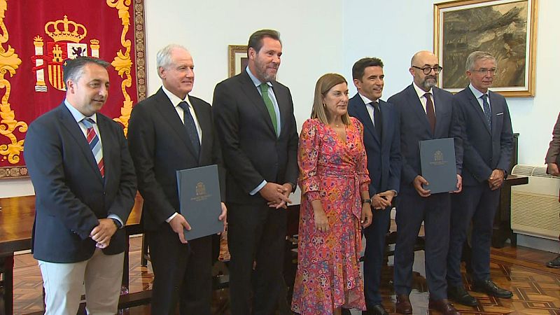 Acto de firma con Roberto Media, María José Sáenz de Buruaga y Óscar Puente, entre otros, posando para los medios en una sala oficial.