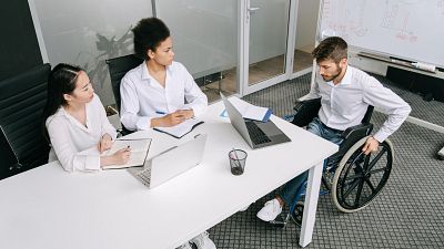 Un grupo diverso de colegas en una reuni�n de negocios discutiendo ideas en interiores.