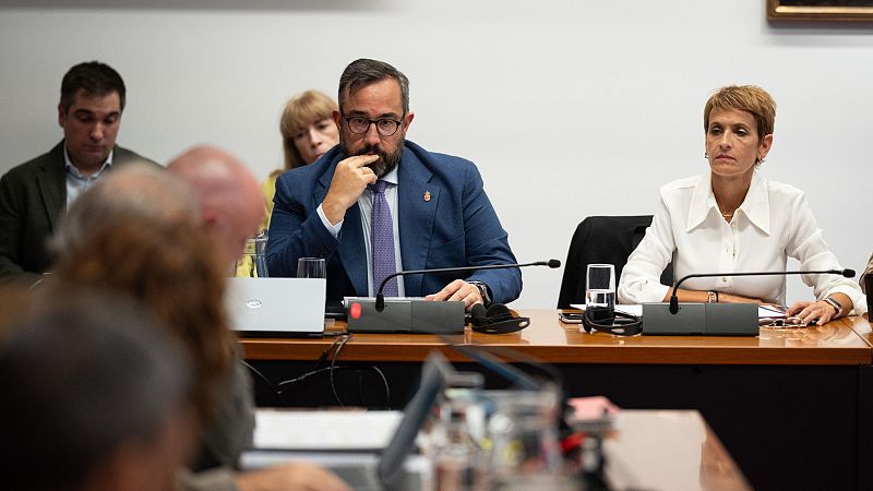 María Chivite, Presidenta del Gobierno de Navarra, y Javier Remírez, ex Vicepresidente, en una reunión. Ambos sentados a una mesa con micrófonos.
