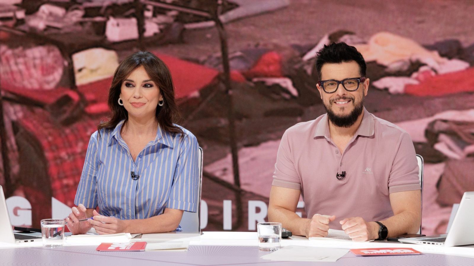 Nuria Marín y Omar Suárez presentan un programa en un estudio, con un fondo caótico y el título "G DIR" visible.