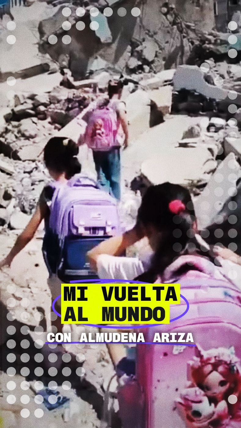 Jóvenes caminan entre escombros bajo el título "MI VUELTA AL MUNDO CON ALMUDENA ARIZA", sugiriendo un reportaje sobre infancia en zonas afectadas.