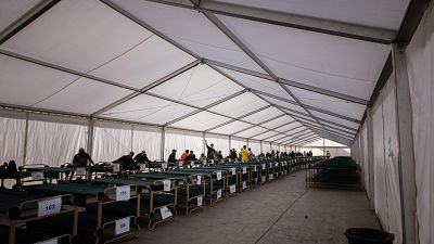 Un grupo de inmigrantes que han sido realojados desde las playas de Ben�tez y el Trampol�n de Ceuta a su llegada este viernes al campamento temporal habilitado en el puerto de la ciudad