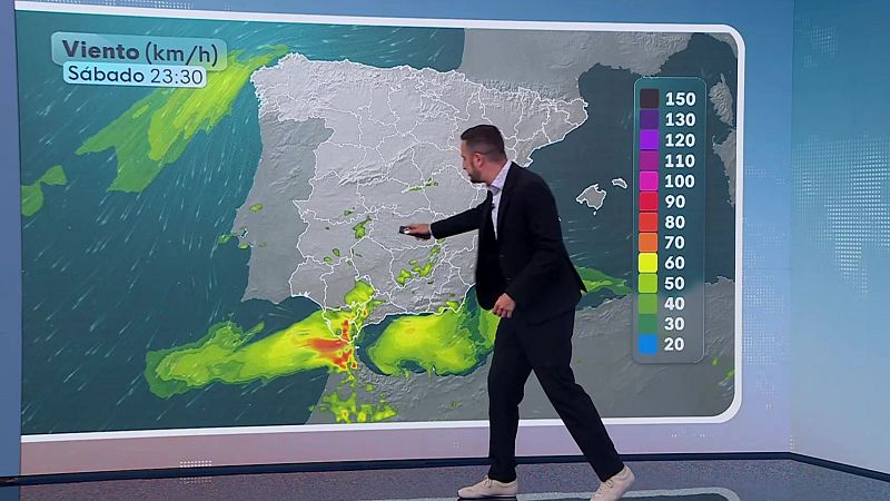 Presentador de televisión señalando un mapa meteorológico de la Península Ibérica y Baleares, con información de viento (km/h) para el sábado a las 23:30.