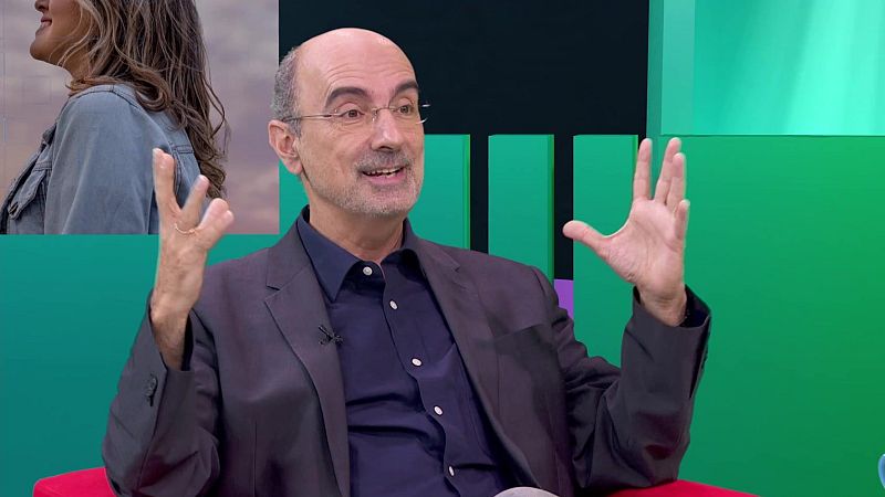 Eduard Punset, con gafas y barba canosa, sonríe y habla en un estudio de TV. En un recuadro superior izquierdo, el perfil de una mujer con cabello largo y chaqueta vaquera.