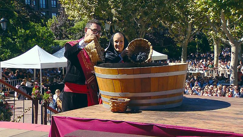 Introducción de racimos de uva riojana en el tinaco para la ofrenda