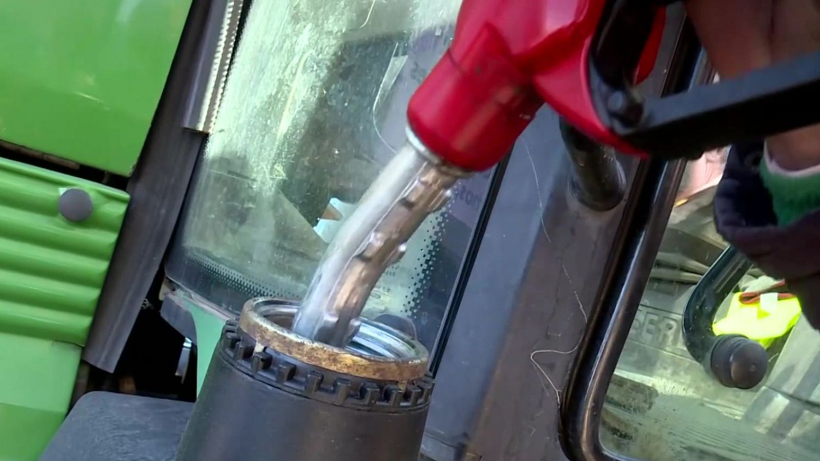 Un agricultor llenando el depósito de combustible