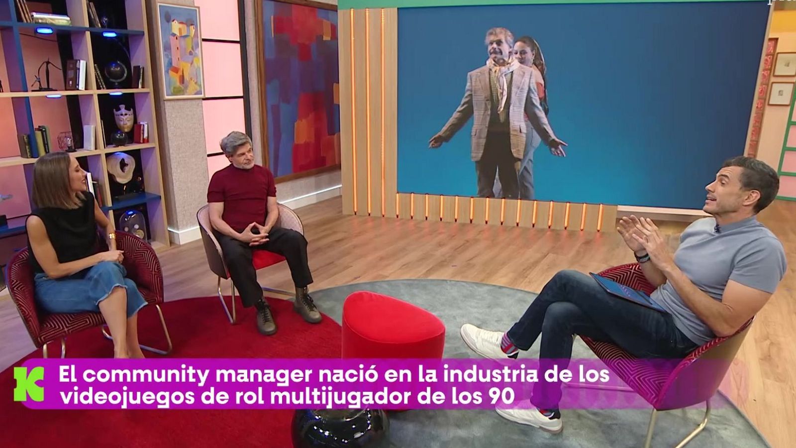 Nuria Roca, Juan del Val y Roberto Leal en un plató de TV. Pantalla al fondo con imagen. Texto: 'El community manager nació en la industria de los videojuegos de rol multijugador de los 90'.