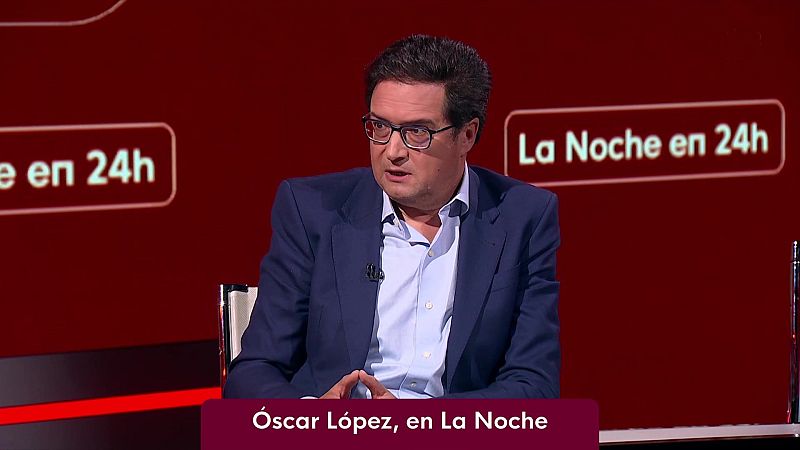 �scar L�pez, pol�tico espa�ol, en plat� de TV con fondo granate y logo "La Noche en 24h". Viste traje azul oscuro, gafas y micr�fono.