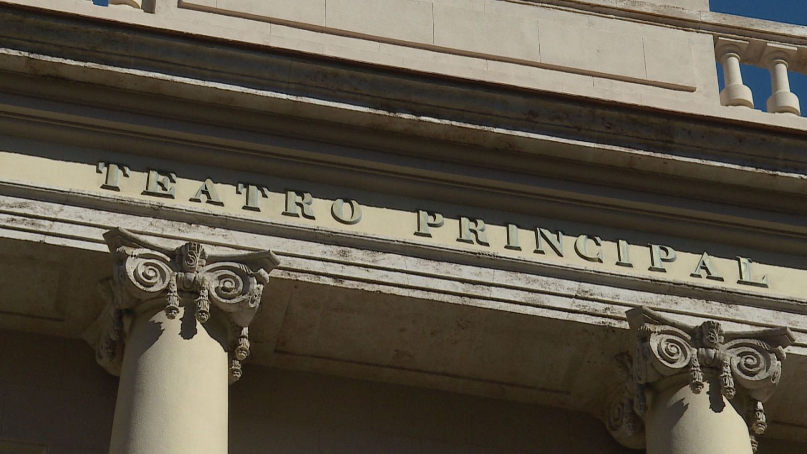 Fachada superior del "TEATRO PRINCIPAL" con letras en relieve, capiteles jónicos y balaustrada bajo luz solar intensa.