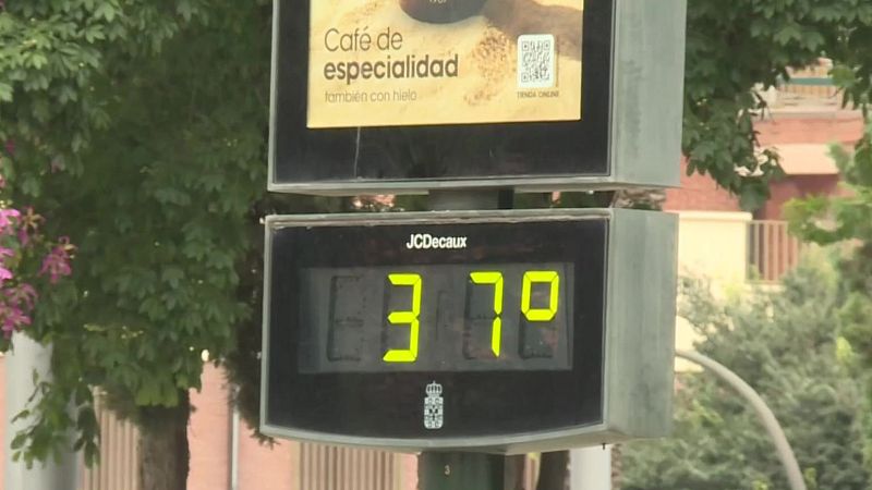Termómetro de calle marca "JCDecaux" muestra 37.9°C. Publicidad de "Café de especialidad" con código QR.