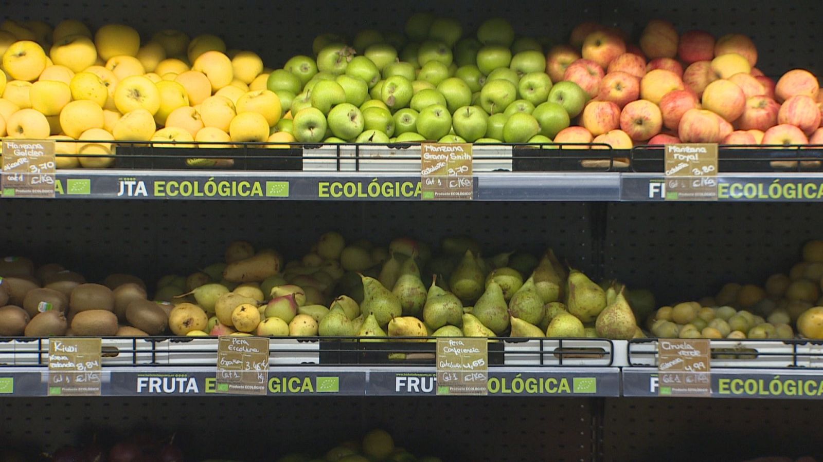 Estantes de supermercado con manzanas Golden, Granny Smith y Royal, junto a kiwis y peras Ercolina y Conferencia, todos etiquetados como ecológicos.