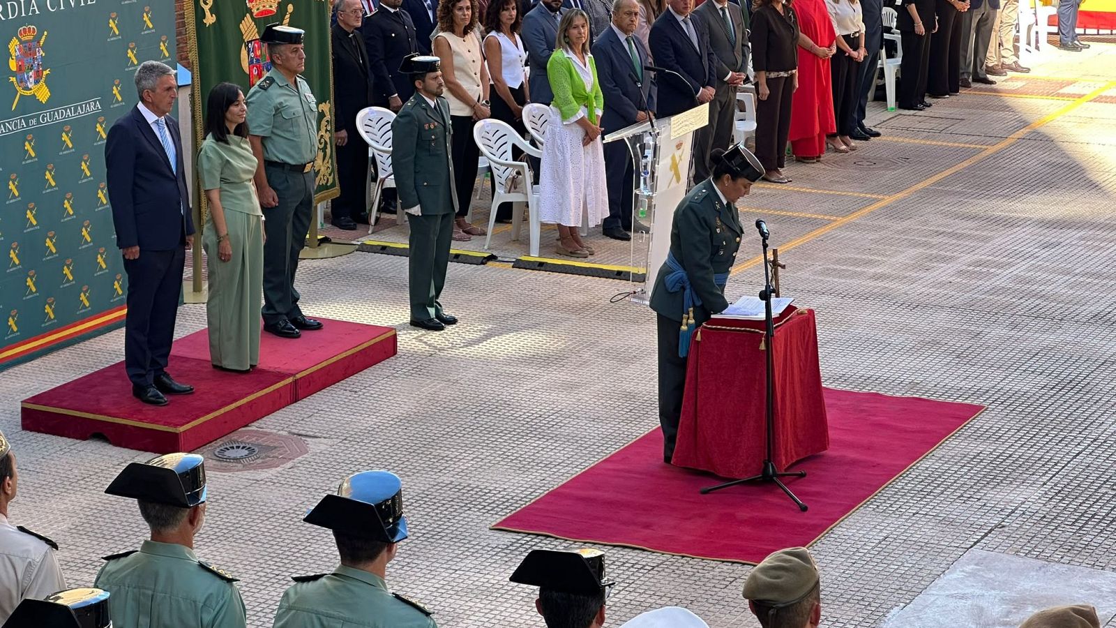Ceremonia oficial de la Guardia Civil en Guadalajara con Emiliano García-Page presente. Agentes uniformados y público asisten al evento al aire libre.