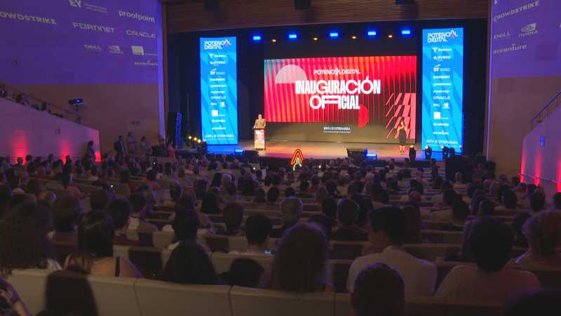 Auditorio lleno en la inauguración de "POTENCIA DIGITAL", con pantalla LED mostrando "JUNTA DE EXTREMADURA" y logotipos de CROWDSTRIKE, EY, proofpoint, FORTINET, ORACLE, DELL, NVIDIA, accenture.