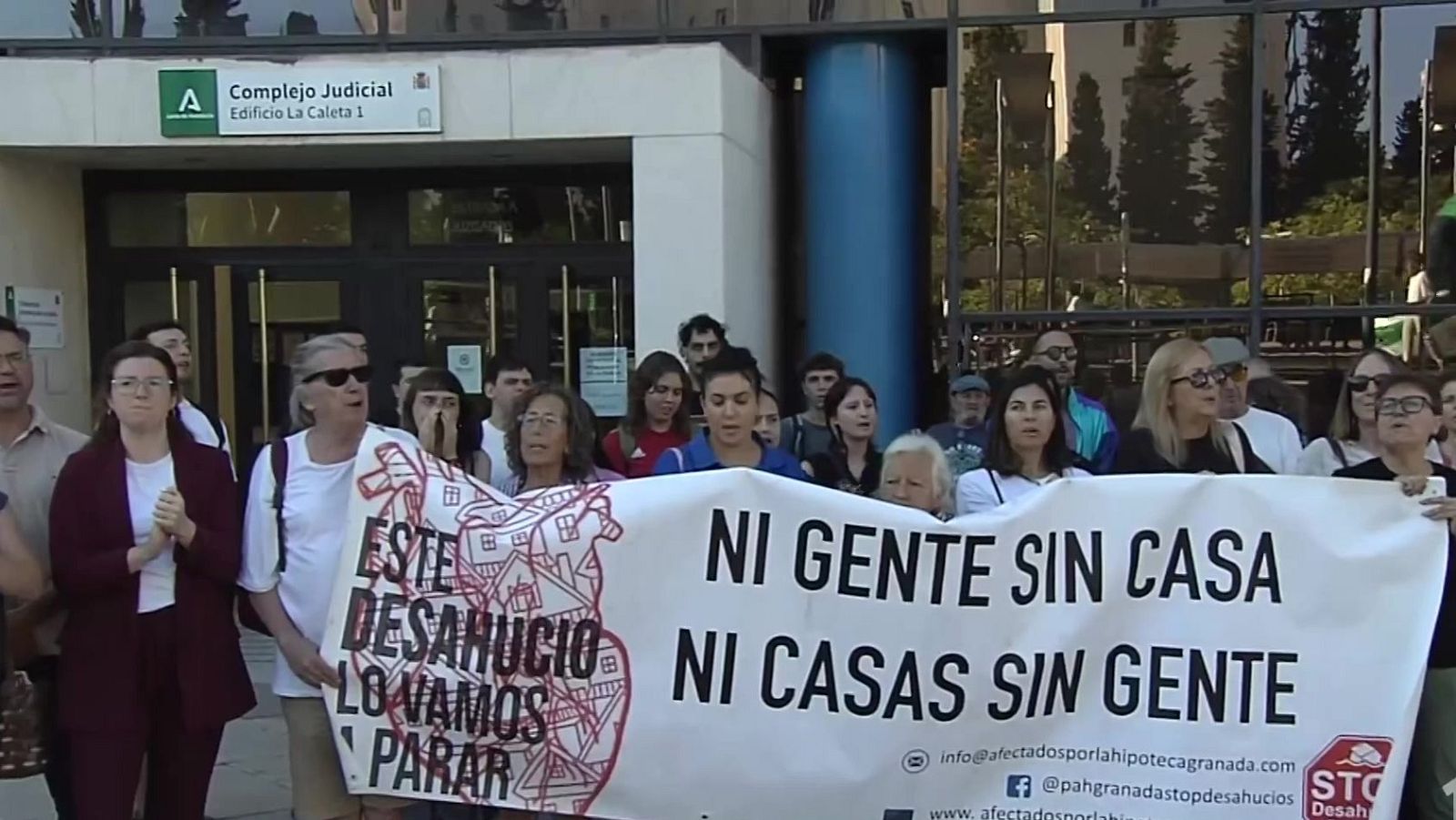 Manifestantes frente al Complejo Judicial Edificio La Caleta 1 en Granada, con pancarta "NI GENTE SIN CASA NI CASAS SIN GENTE" y "ESTE DESAHUCIO LO VAMOS A PARAR".
