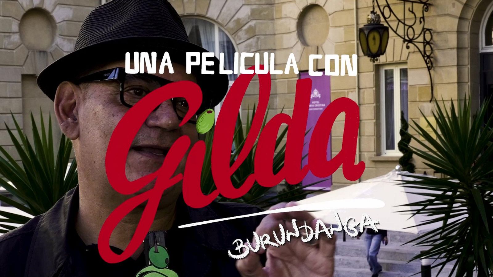 José Corbacho, con sombrero y gafas, promociona "UNA PELÍCULA CON Gilda BURUNDANGA" frente al Hotel María Cristina en el Festival de Cine de San Sebastián.
