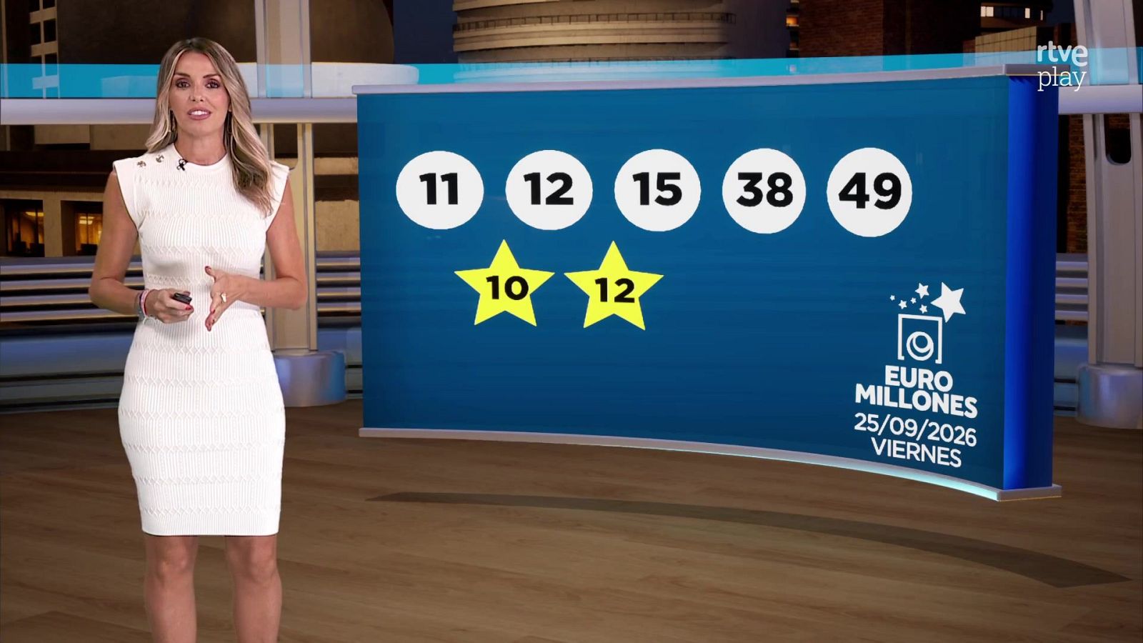 Sandra Daviú, presentadora, en estudio de TV con vestido blanco, frente a panel de Euro Millones con números, estrellas y fecha 25/09/2026.