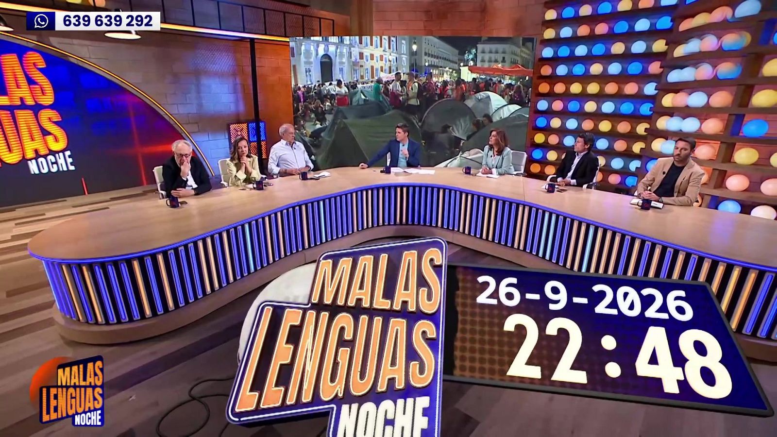 Estudio de "MALAS LENGUAS NOCHE" con Antonio Naranjo, Javier Cárdenas y Albert Castillón. Fondo urbano con tiendas. Fecha: 26-9-2026, Hora: 22:48. Teléfono: 639 639 292.