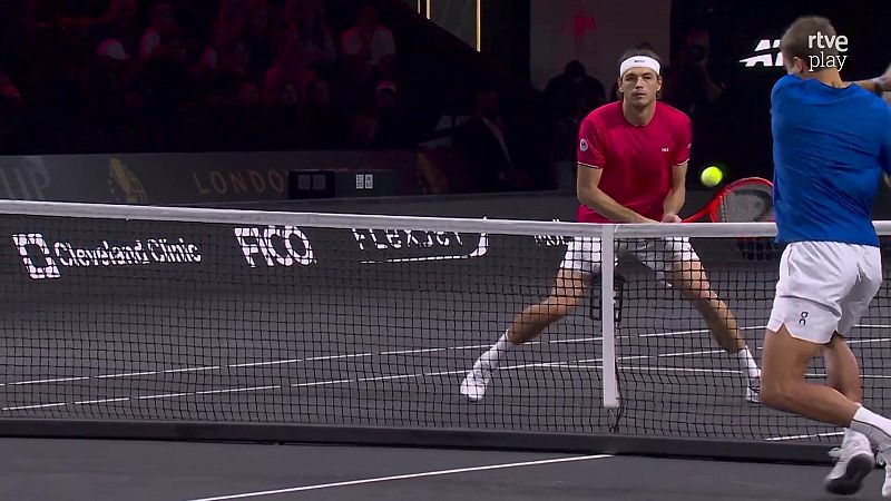 Taylor Fritz en acci�n en una cancha de tenis cubierta, con la pelota sobre la red. Se aprecian logotipos de Cleveland Clinic y FICO.