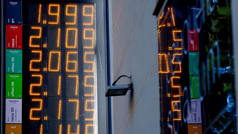 Panel digital de una gasolinera Repsol que muestra precios de combustibles como Diésel e+ a 1.999 € y Gasolina Efitec 95 a 2.065 € en dígitos LED naranjas, con un reflejo a la derecha.