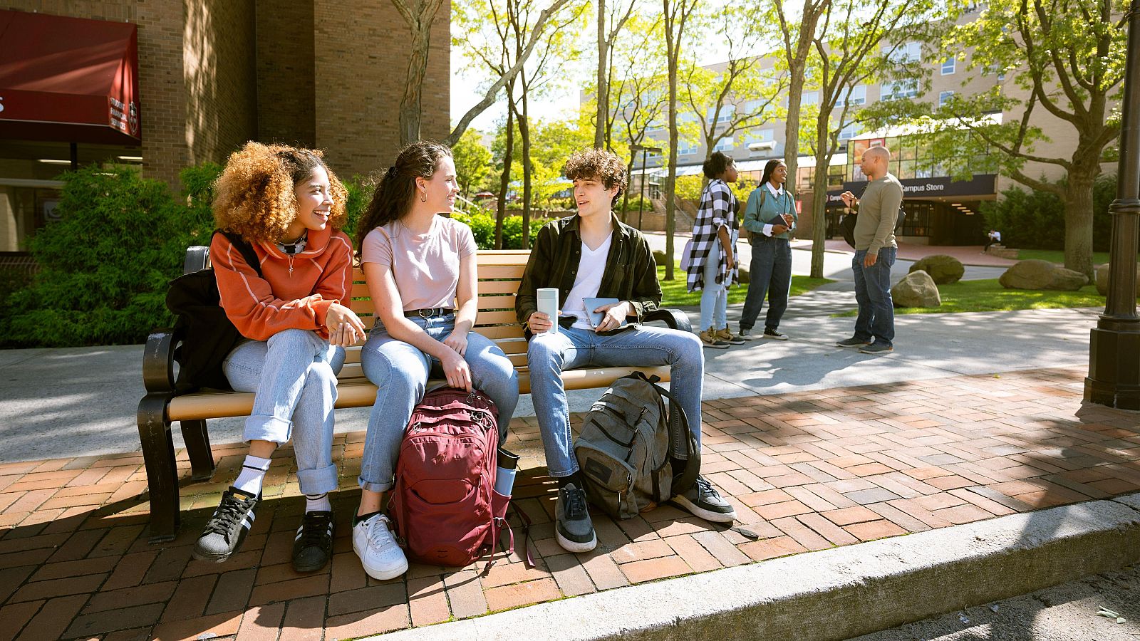 Estudiantes universitarios esperan el autobús en el campus.