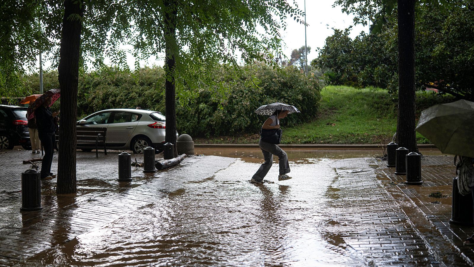 Una persona camina bajo la lluvia por la calle en el barrio de Canyelles-Nou Barris, Barcelona
