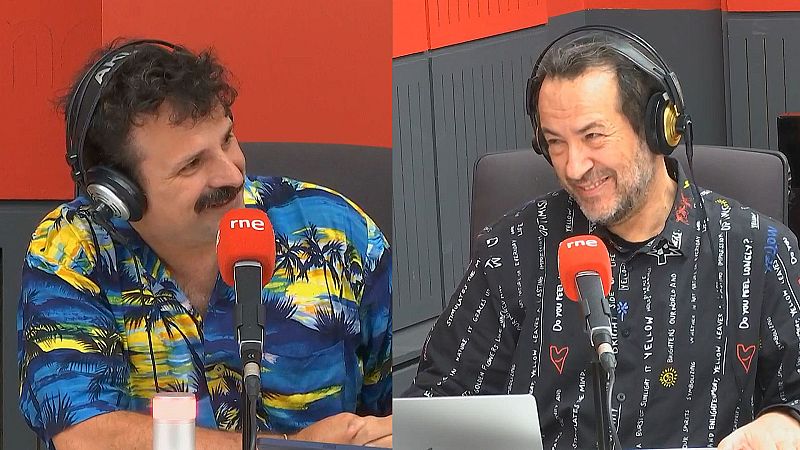 Ángel Carmona, con camisa hawaiana, y Luis Ángel de Benito, con camisa negra con textos escritos, sonríen con auriculares frente a micrófonos de RNE en un estudio de radio.