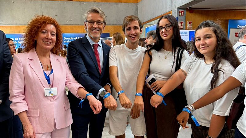 El consejero de Empleo, Luis Alberto Marín; la directora del SEF, Pilar Valero, y un grupo de asistentes a la V Feria de Empleo muestran las pulseras digitales que permiten entregar el CV de manera telemática