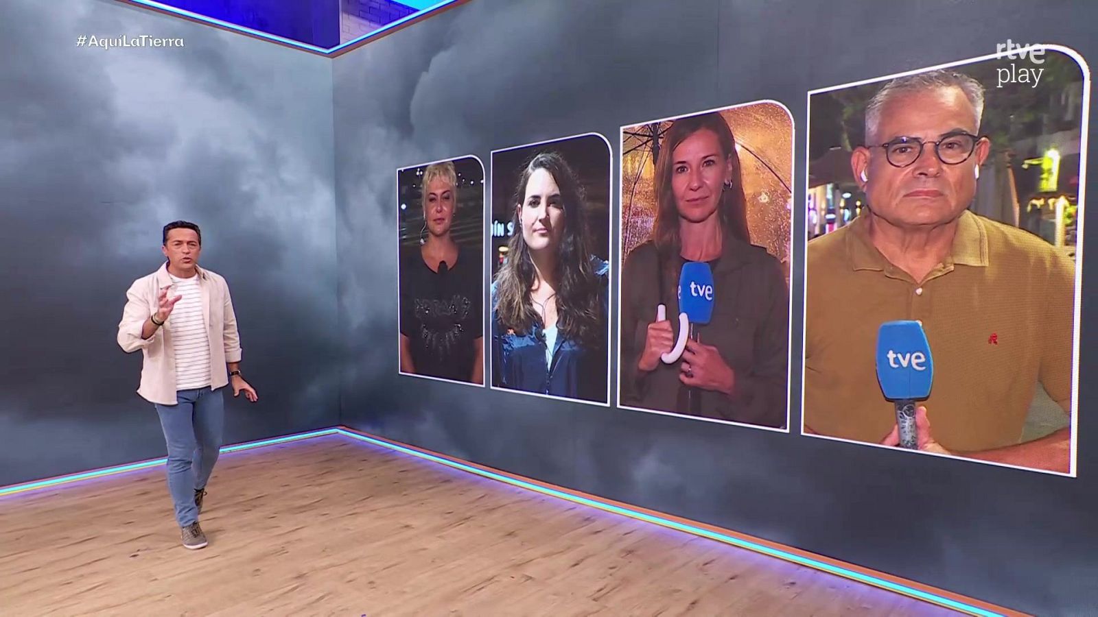 Quico Taronjí presenta "Aquí la Tierra" frente a una pantalla con cuatro reporteros en directo, bajo un fondo de nubes grises y los logotipos del programa y de rtve play.