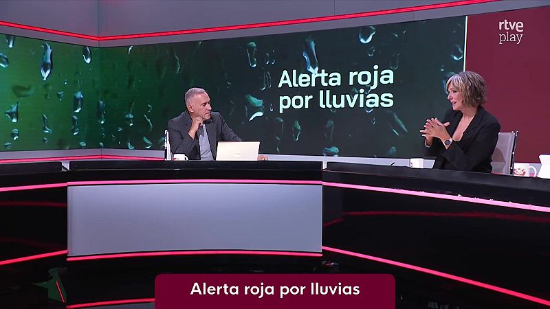 Dos presentadores conversan en el plat� de un programa informativo ante una pantalla con el r�tulo �Alerta roja por lluvias�.