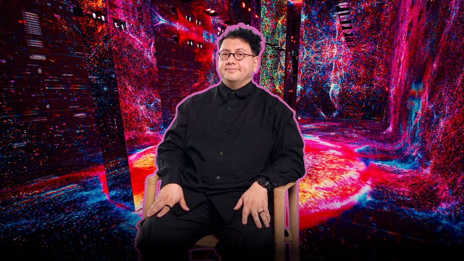 El artista digital Refik Anadol, con gafas redondas y camisa negra, aparece con un resplandor fucsia frente a una instalación de arte digital con patrones fluidos de colores intensos.