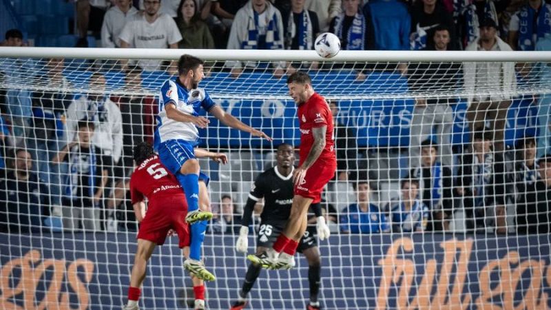 Intenso duelo a�reo junto a la porter�a entre futbolistas del CE Sabadell y del FC Andorra durante un partido de f�tbol.