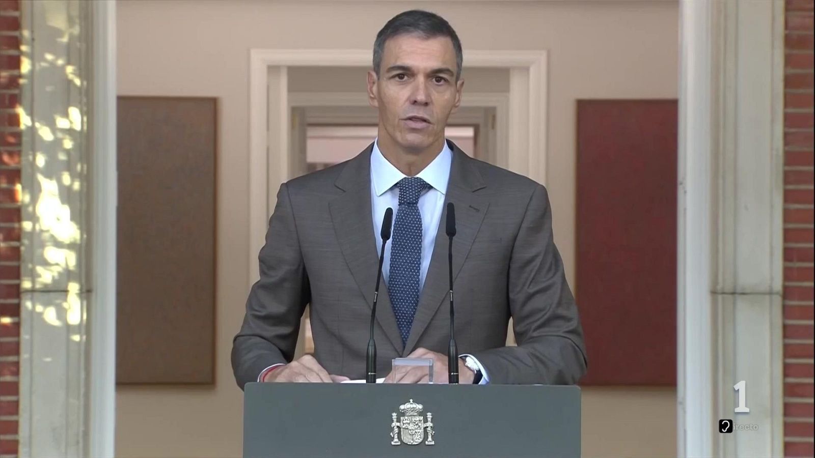 Pedro Sánchez comparece serio ante un atril con el escudo de España en el Palacio de la Moncloa.
