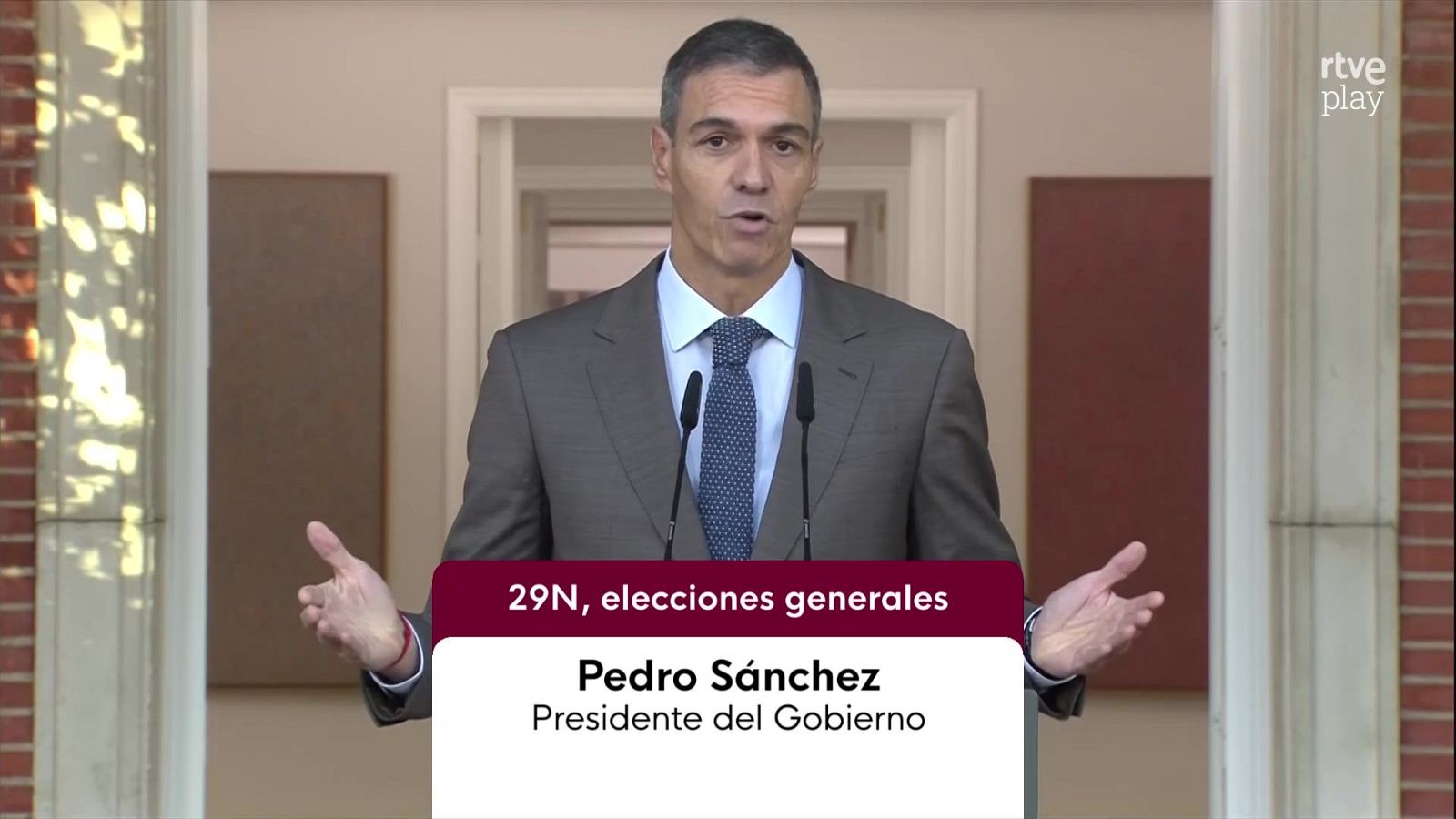 Pedro Sánchez comparece en el Palacio de La Moncloa vistiendo traje gris y gesticulando frente a unos micrófonos durante una emisión informativa.