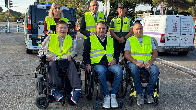 Seis personas posan en un entorno vial junto a furgonetas oficiales durante una presentación de seguridad vial.