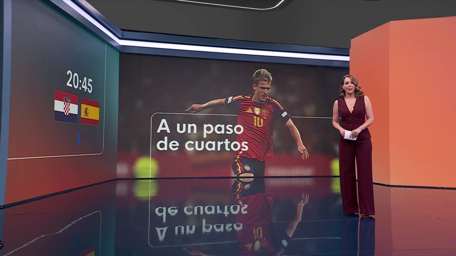 La periodista Lara Gandarillas presenta en el plató de informativos junto a un videowall con gráficos de fútbol y la imagen del jugador Rodri Sánchez.