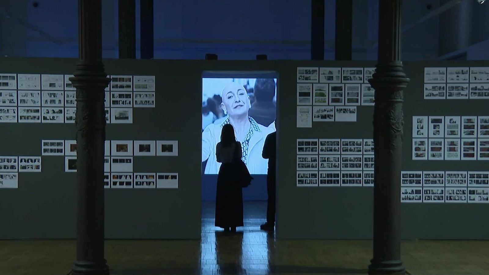 La cineasta Paula Ortiz contempla una pantalla iluminada en una exposición sobre su obra cinematográfica.