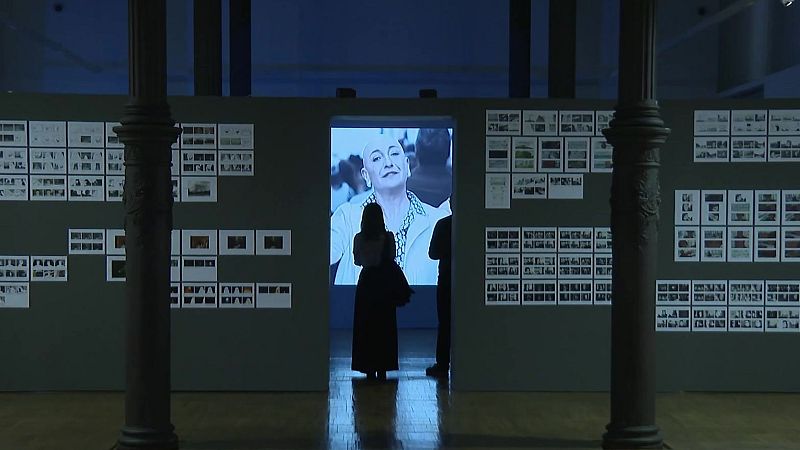La cineasta Paula Ortiz contempla una pantalla iluminada en una exposición sobre su obra cinematográfica.