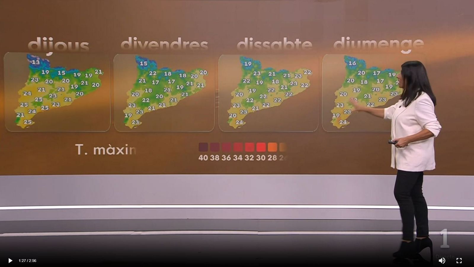 La meteoróloga Sònia Papell presenta el tiempo de perfil, señalando un panel gigante con mapas de temperaturas de Cataluña.