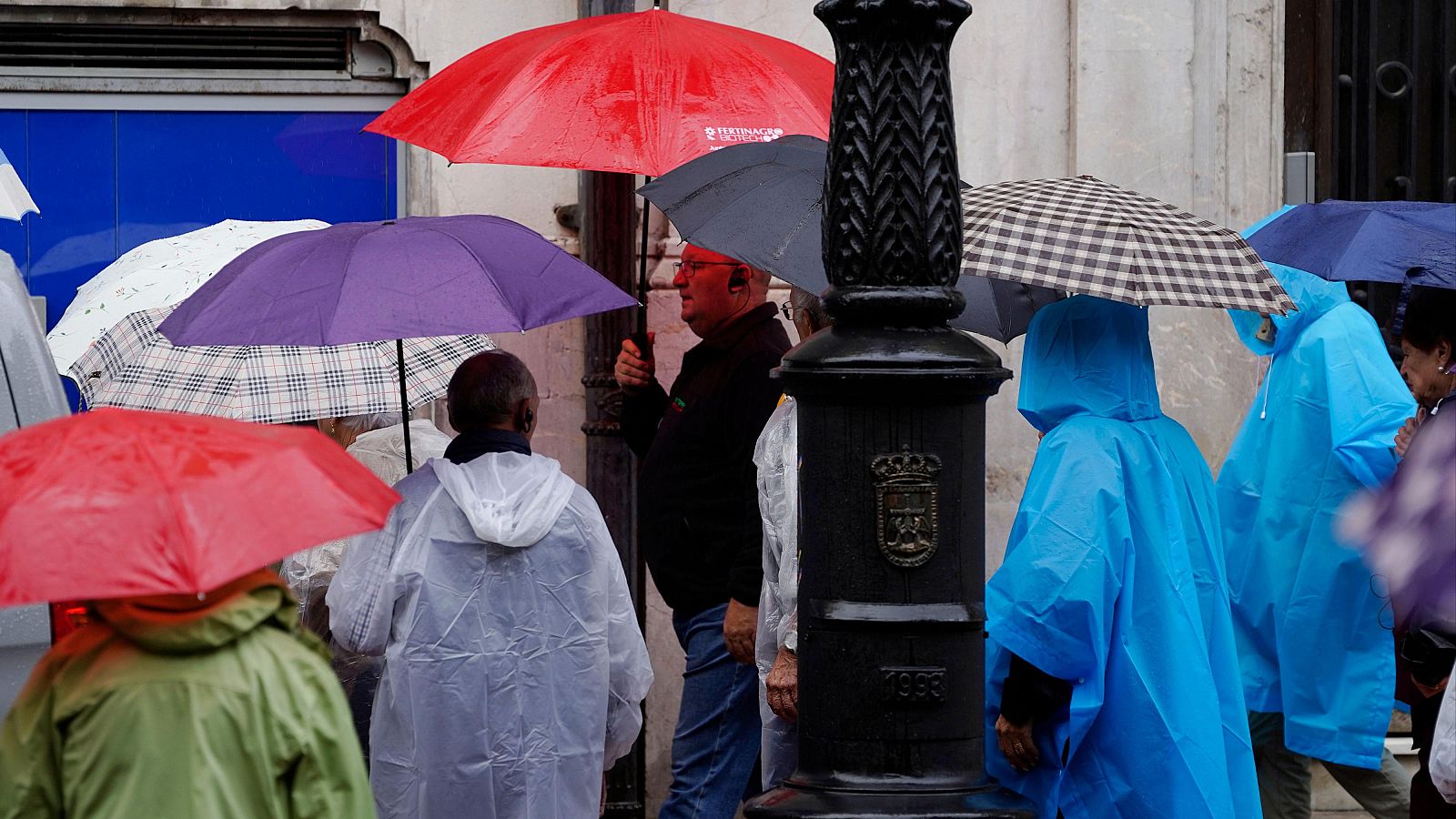 Turistas protegiéndose de la lluvia en el centro de Oviedo