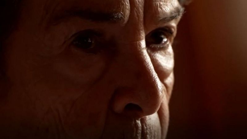 Primer plano muy cerrado del rostro de una mujer mayor con ojos oscuros y expresivos, arrugas visibles y una iluminación lateral dramática que transmite gran intensidad y seriedad.