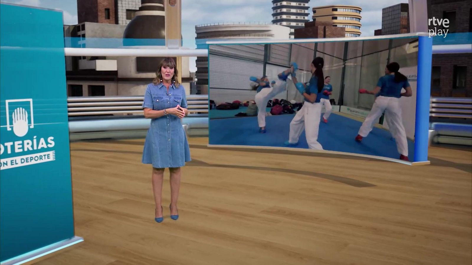 La presentadora Sandra Daviú presenta en plató junto a una pantalla con imágenes de kárate y el logotipo de rtve play.