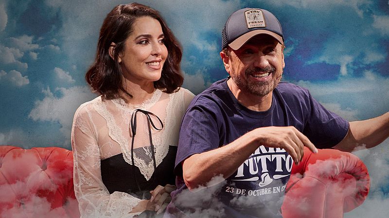 Ruth Lorenzo y José Mota posan sonrientes sobre un sofá rojo en un escenario decorado con nubes y niebla.