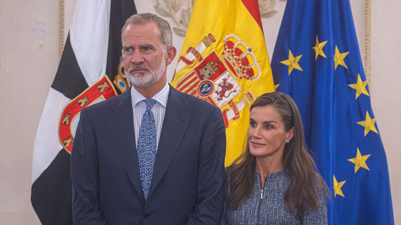 Los reyes Felipe VI y Letizia posan juntos en un acto oficial frente a las banderas de Ceuta, España y la Unión Europea.
