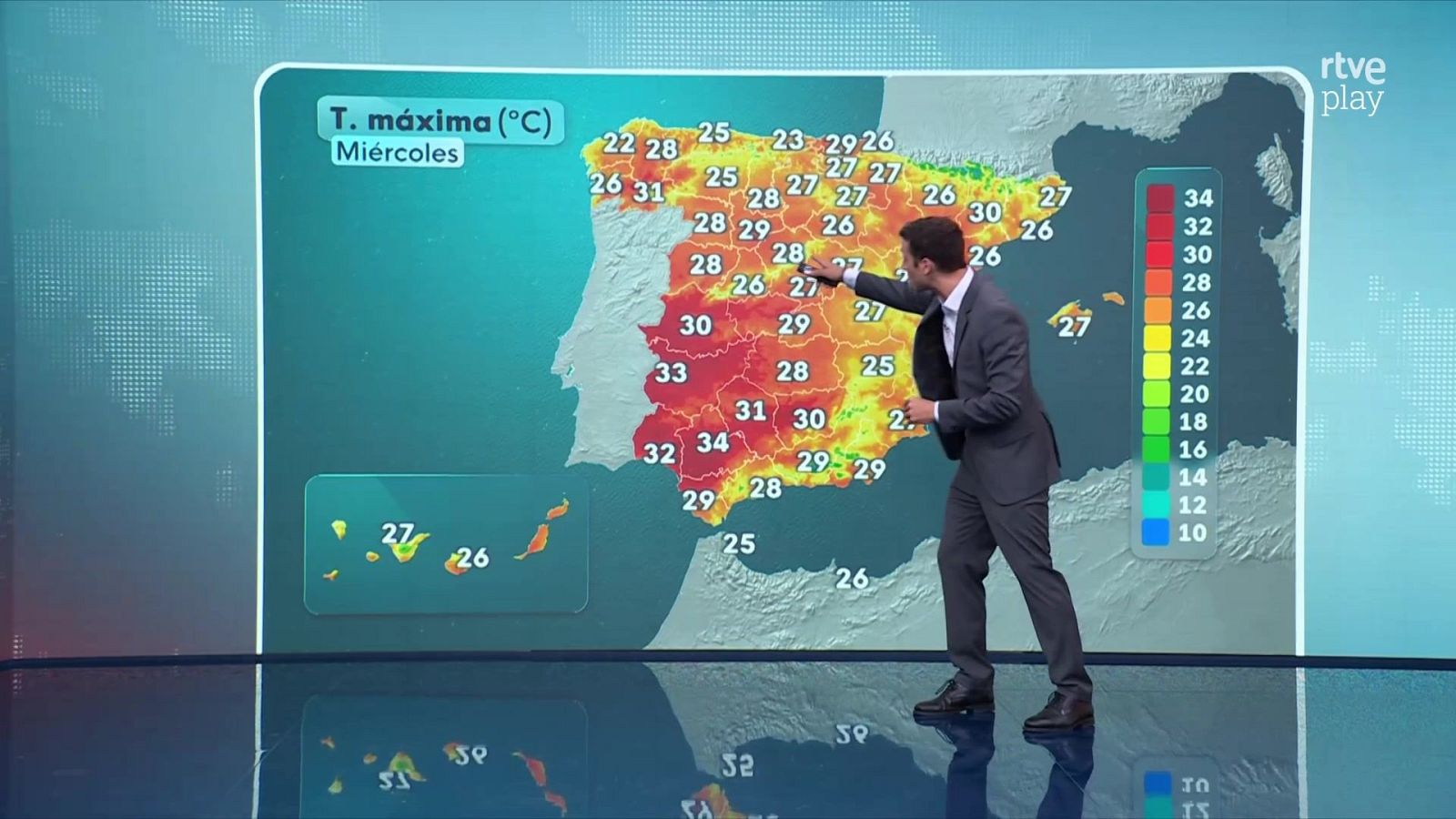 El presentador Marc Santandreu señala un mapa meteorológico de España en una pantalla gigante que muestra temperaturas máximas de hasta 34 grados.