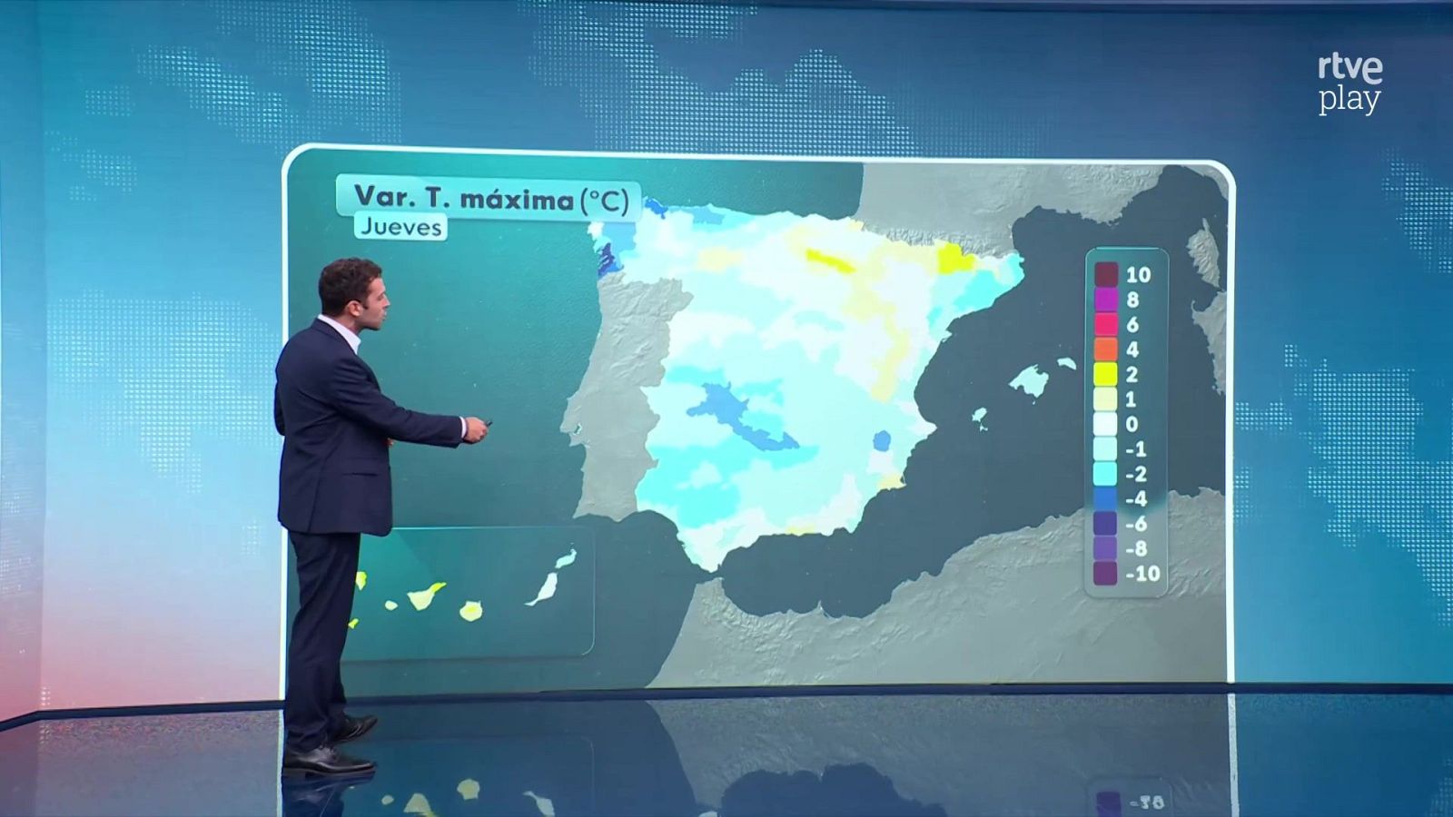 Presentador de pie en un plató frente a una gran pantalla que muestra un mapa de España con la variación de temperaturas máximas en tonos azules y amarillos.