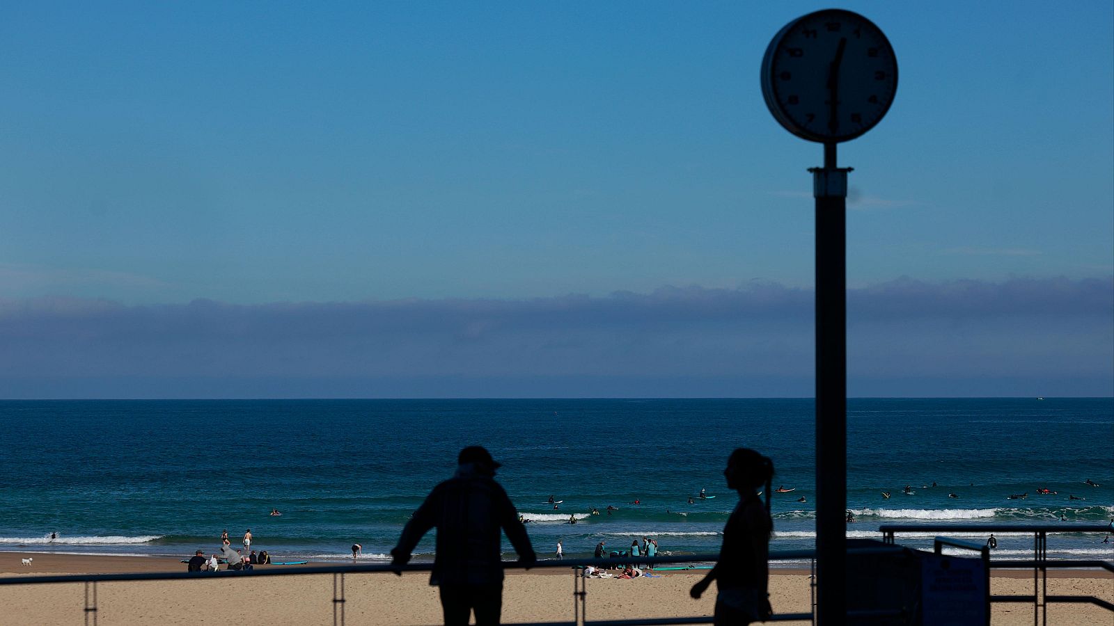 Bañistas y paseantes disfrutan de un día soleado en la playa de la Zurriola de San Sebastián