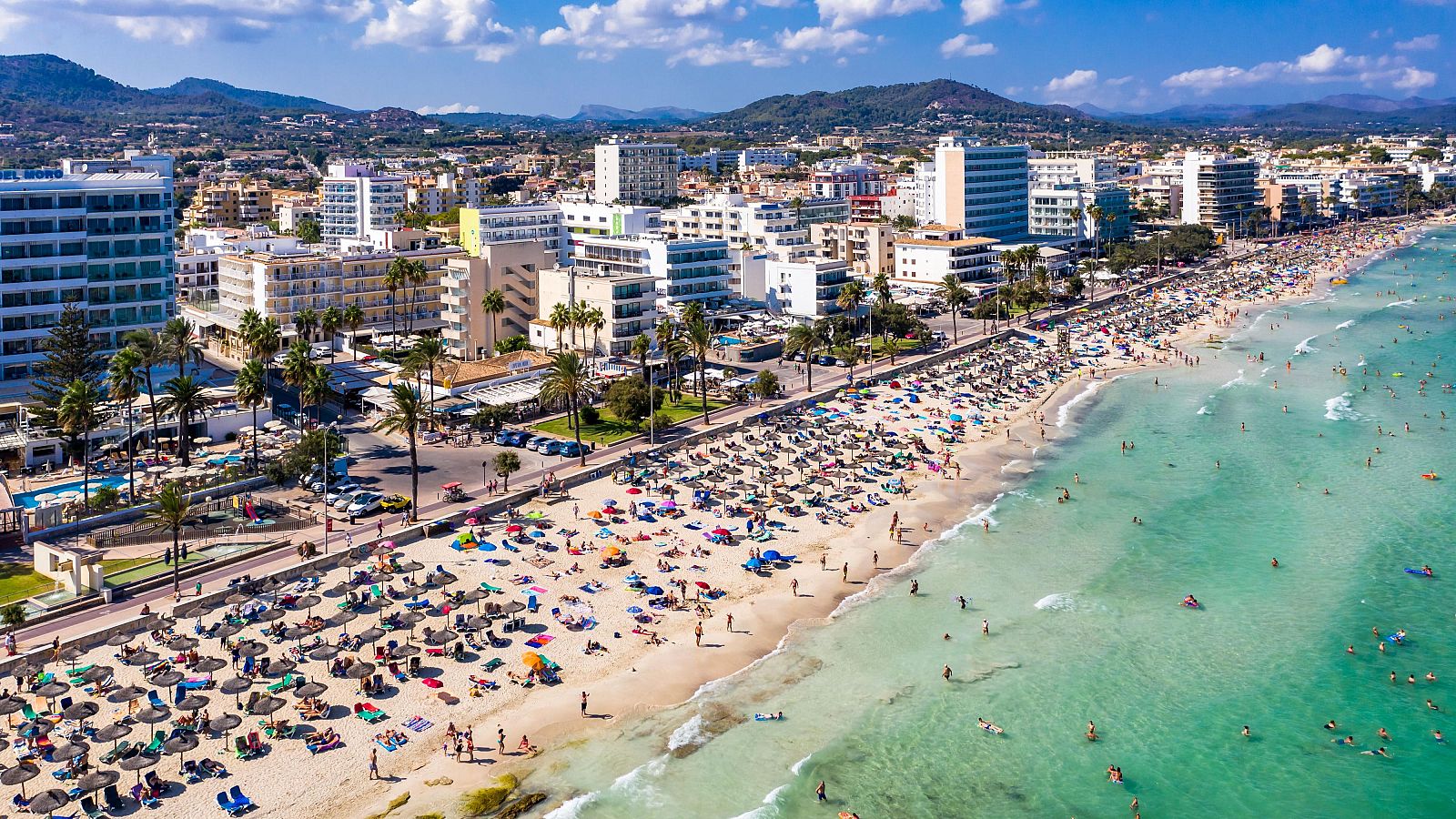 Playa de Cala Bona, Mallorca, con cientos de bañistas, tumbonas y sombrillas