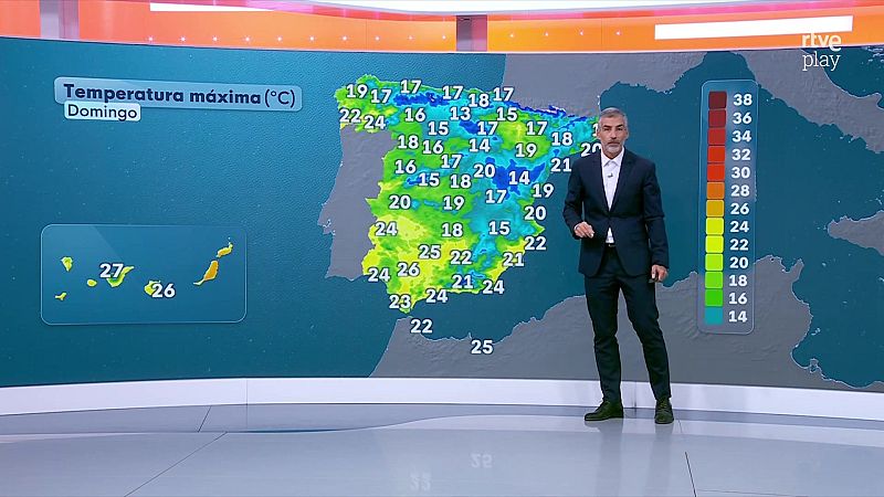 Un presentador con traje oscuro explica un mapa de España con temperaturas máximas frente a una gran pantalla curva en un plató de televisión.