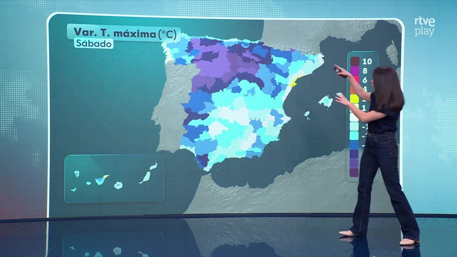 Presentadora en plató señalando un mapa de la península ibérica con previsión de temperaturas.