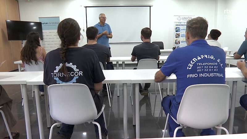 Docente imparte formación técnica ante alumnos en un aula, con elementos corporativos y la marca de agua rtve play visible.